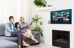 Family watching live channels and movies on a smart TV with Alfa IPTV